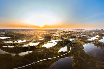 Warmly colored sunrise over a foggy swamp. Aerial view of stunning landscape at peat bog at Kemeri...