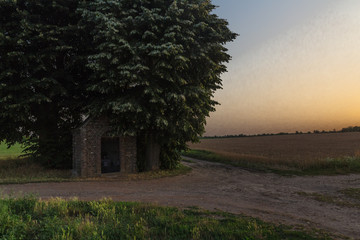 small chapel symbol of the catholic region in the field near Maastricht during sunset