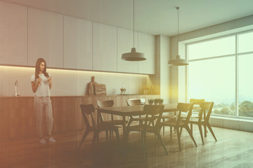 Woman in white kitchen corner with table