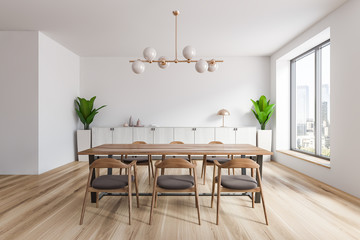 White dining room interior with wooden floor