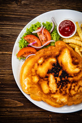 Fried pork chop with french fries and vegetable salad