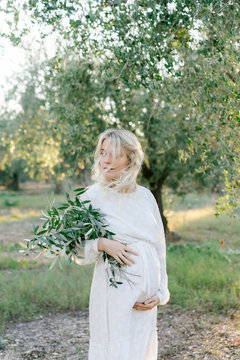 Pregnant lady with olive branches looking away