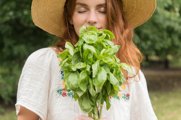 Woman smelling freshly picked basil