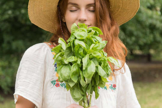 Woman smelling freshly picked basil