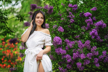 portrait of girl in white dress in front of the purple flowers