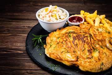 Fried pork chop, French fries and vegetable salad