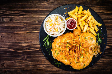 Fried pork chop, French fries and vegetable salad
