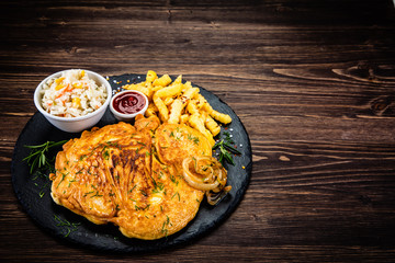 Fried pork chop, French fries and vegetable salad