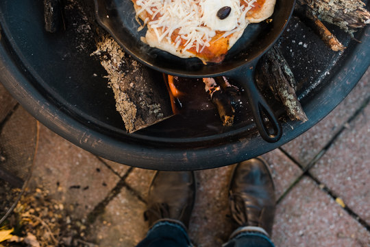 pizza cooking on a fire pit