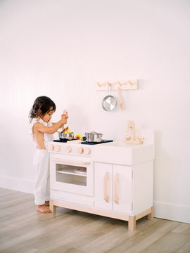 Toddler Playing With Play Kitchen