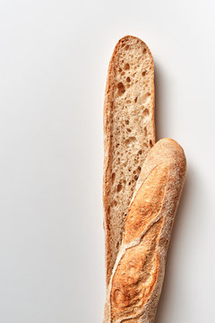 Cut organic baguette presented on a gray background with copy space. Flat lay
