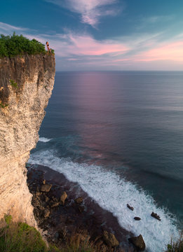 Young woman watching the sunset at Uluwatu
