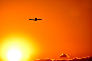 Fototapeta na wymiar 美しい夕焼け雲の空・夕日を背景に飛行する航空機・セスナ機(シルエット)景色 撮影場所：日本(秋) 「九州・熊本県」Beautiful sunset Cloud sky, aircraft flying against the backdrop of the setting sun, Cessna aircraft (silhouette) scenery Location: Japan