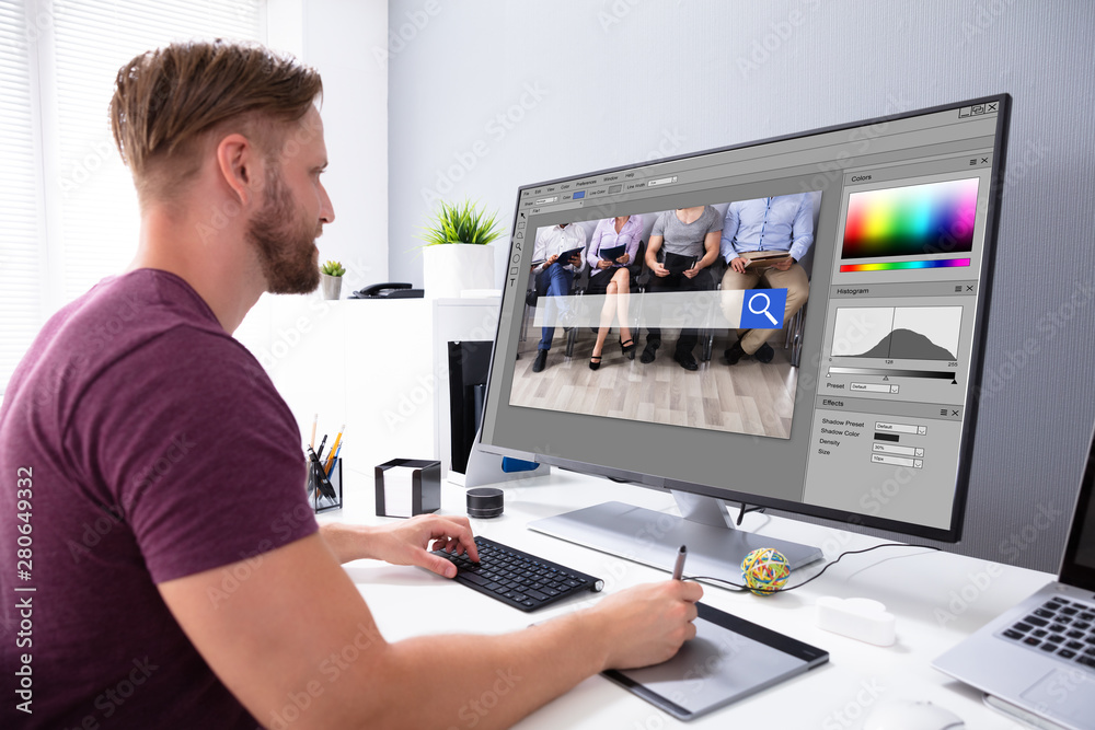 Poster designer editing photo on computer