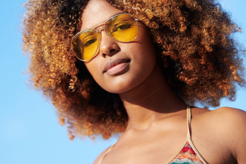 Confident black woman in sunglasses and bikini