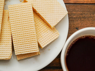 Waffles on a white plate and a cup of black tea, Top view. Close up.