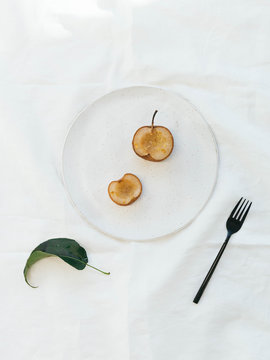 Roasted Japanese pears with ground ginger on ceramic plate and white linen cloth