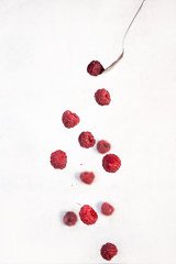 fresh red raspberries falling isolated on white background
