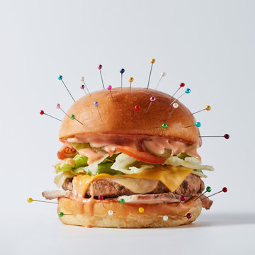 Burger as an object of a voodoo doll with needles for a ritual o