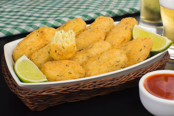 Traditional recipe codfish balls in black background with one cuted