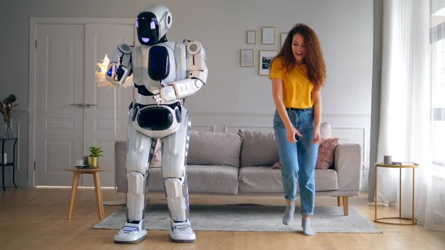 Living room with a lady and a robot dancing joyfully