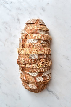 Slices of multigrain organic homemade bread on a gray stone background. Top view.