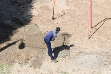 Worker rake dub sand.