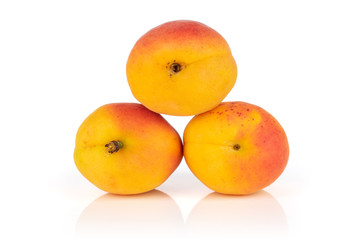 Group of three whole fresh orange apricot arranged to a pyramid isolated on white background