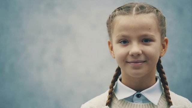 Cute schoolkid is looking at the camera with inquisitive eyes.