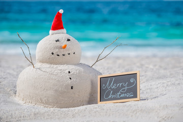 Australian Christmas Sandman with decoration and with a board of Merry Christmas text on a...