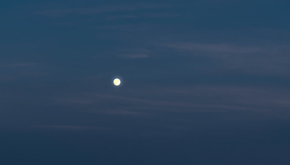 Moon in the evening sky during blue hour.