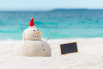 Australian Christmas Sandman with an empty board - place for your text - on a beautiful white sand beach 