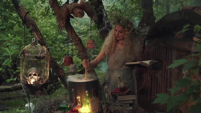 creating potion of immortality, wise forest goddess with wreath stirs white light steam in cauldron, woman with blond lush curly hair with open book in hand, raises wooden spoon and looks at result