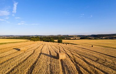 Gemähtes Getreide Feld mit Heuballen bei Sonnenuntergang