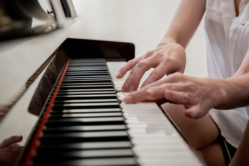 hands play piano keys