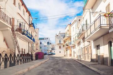 The narrow streets of the island with blue balconies, stairs and flowers.