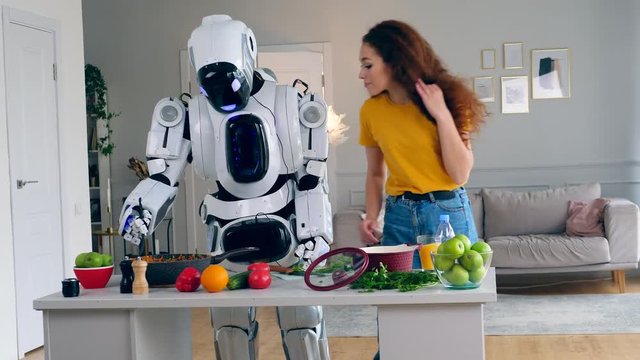 Young woman is trying food cooked by a cyborg