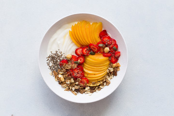 Healthy breakfast. Greek yogurt with fresh apricots, strawberries, walnuts, muesli and honey. Top view