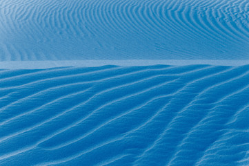 Fototapeta premium Sand texture background. Blue tint.
