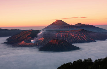 Mount Bromo glowing in golden light at sunrise, a popular tourist destination in Indonesia