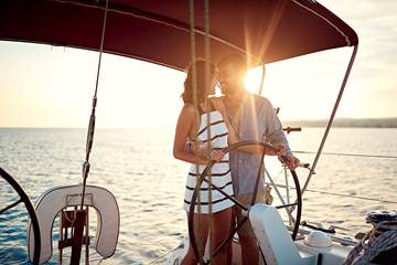 Romantic couple on boat enjoy together at sunset.