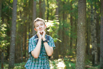 teenager boy walking in the forest alone in the summer day