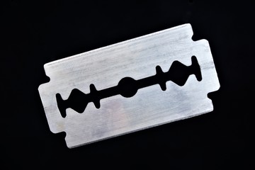 Razor blade on black background. The razor blade is a flat metal plate, it is a shaving tool. The...
