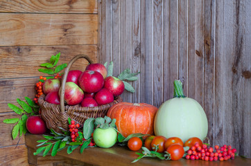 vegetables and fruits in a basket on a wooden background. harvesting autumn and summer harvest. pumpkin, zucchini, apple, rowan, pea, cherry. soft focus. copy space.