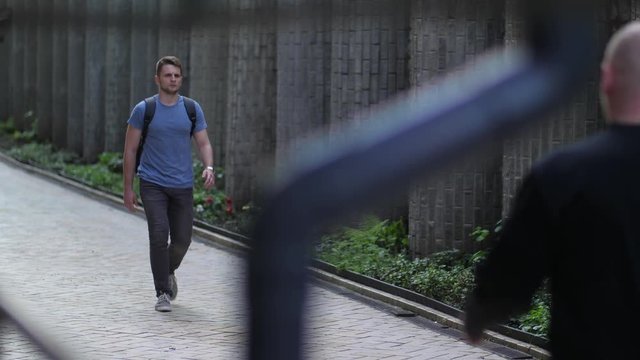 Group of muggers attacking male walking alone in the middle of day. Brave young man using skill of self defense techniques neutralizing thugs knocking them out on street and running away