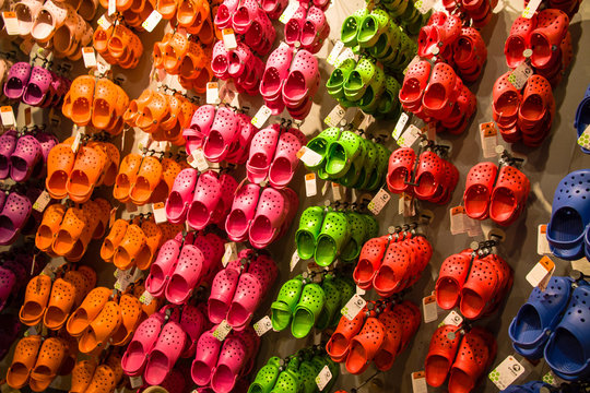 NEW YORK CITY, USA - JUL 17, 2010: Crocs soft rubber children sandals hanging on a rack display for sale. Colourful sandals of diverse colours blue, red, pink, green, orange.
