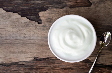 Fresh yogurt In white glass on wood background from top view.