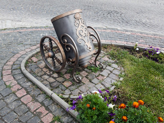 Naklejka premium The original trash can in the old town. Forged metal