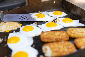 Eggs and hashbrowns on the grill cooking for breakfast