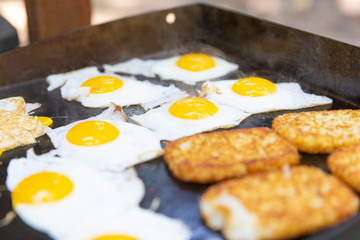 Eggs and hashbrowns on the grill cooking for breakfast